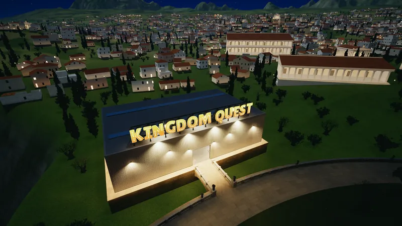An aerial view at night of a warehouse with a lit KINGDOM QUEST marquee sign on its roof, beside a town of white houses.